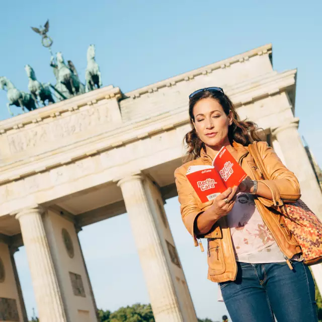 Frau mit Berlin Welcome Card Guide vor dem Brandenburger Tor