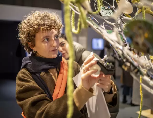 Foto: Frau experimentiert mit einer Iode, die sie an Ausstellungsstück anbringt